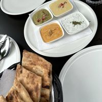 Vorspeise aus Fladenbrot und verschiedenen veganen Dips, wie Joghurt Minze, Hummus, Daal und Zucchini.   at Maihan in Hamburg
