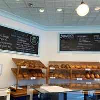 Bread displayed under signs about their offerings at Allegro Bakery in Pittsburgh