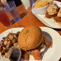 Campfire Burger with breakfast potatoes. Chicken Biscuits behind with Cheesy Fries  at Brunch Bird in Austin