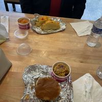 Deep Sea Fish sandwich and truffle potatoes in the foreground; Spanish Sea Shell tacos and rice in the background.  at Deep Sea Vegan in Nashville