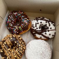Clockwise from top left: chocolate frosted with sprinkles, vanilla frosted with chocolate chips, raspberry jam (filled), Snickers  at Donut Run in Washington