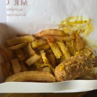 Bartered vegan sausage (half-eaten), chips and curry sauce.   at Mr Chippy in York