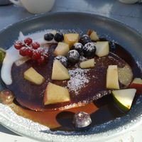 a "dutch baby" is a crossover between a pancake and a soufflé: quite eggy/chewy, covered with a sweet sauce and served with fresh fruits at Superkelly in Ghent