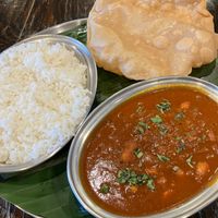 Pondu Puli Kolambu & side of Poori bread. Vegetarian & diary free. A tangy curry made with tamarind & about 15 roasted garlic cloves - amazingly flavorful & not too garlicky! at Kumar's Minneapolis in Apple Valley