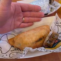 Empanada, with hand for scale at Arempas in Salt Lake City
