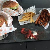 Tofu burger (left), blackbean burger (rear), super crunchy fries, sweet potato fries, and sweet sesame balls at Kenkō Burger in Leipzig