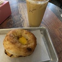 Pistachio latte and vegan breakfast sandwich (sausage, cheese, egg, pepper jelly, bialy)  at Coat Check Coffee in Indianapolis