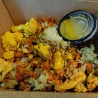 Golden Veggie Bowl 2025. Jasmine rice, turmeric cauliflower, sweet potatoes + parsnips, sunflower seeds, golden shallot vinaigrette  at Chardon Buckeye Chocolate Café in Chardon