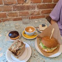 Chickpea patty and tartare sauce sandwich with soda bread, vegan egg mayo brioche, Boston cream doughnut and lemon cheesecake at Baja Wegańska Cukiernia in Warsaw
