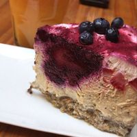 Aparte pedí un cheesecake de frutos rojos y maracuyá, la base es de frutos secos y el relleno lleva tofu. Riquísimo y libre de gluten también. El jugo es de maracuyá y zanahor at Alma Casa Vegana in Cordoba