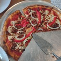 Custom pizza with cashew mozzarella, mushroom bacon, plant based pepperoni, onion, and bell pepper. The flavor is 15/10 at Lucile Pizza & Wine Bar in Sarasota