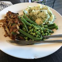 Sage and onion sausages, with onion gravy, smashed herby potatoes, beans and peas  at Green Dinner Table in Christchurch