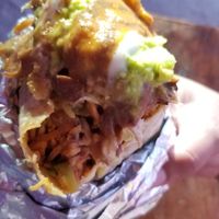 Burrito with all the sauce. Sorry for the blur. Worth it. at Ulu Dos Tres Taco in Zanzibar