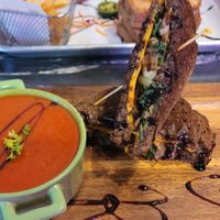 The artist with vegan cheese and a bowl of tomato soup at The Grilled Cheese Gallery in St Augustine