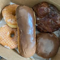 Glazed donuts, chocolate bar, Apple fritter, Boston Cream, all vegan at Friendly Doughnuts in Orange