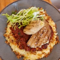 Kohlrabi cutlets on garlic mashed potatoes with marinara sauce at Mana Food - Moabit in Berlin