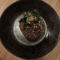 Grauwe erwtentempeh met gedehydrateerde pompoen, zwarte bonenmousse, snijbiet met geroosterde zonnenbloempitten  at Kasvio in Utrecht