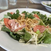 Caesar salad with fried onions and tomato added.   at PiANTA in Providence