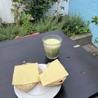 Sourdough bun with vegan butter and cheese and a matcha latte with oat milk   at Brødre Bageri in Tejn