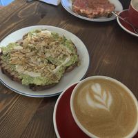 Avocado toast, tomato and aove toast, and coffee with oat milk  at Pum Pum Bakery in Madrid