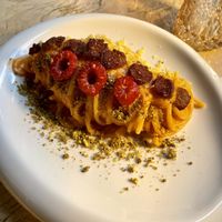 Vegan carbonara made with raspberry sauce, raspberry, pistachios’ crumble and smoked soy sausage.   at Vrindaa in Rome