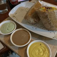 Burrito with side of vegan cheese, Asian and jalapeño Mayo sauce. Sauces are SO good.   at Grow in Puerto Viejo De Talamanca