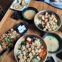 2x lunch deal fried dubu bibimbap including miso soup and soy-sesame sauce, 1x fried cauliflower wings, 1x yachae mandu at Kini in Hamburg