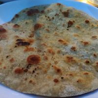 Chapati, a grilled, whole-wheat, unleavened bread from Cinnamon, served June 2021. That evening, the restaurant was out of quinoa, the reviewer's first choice for a starch. at Cinnamon in Rhinebeck