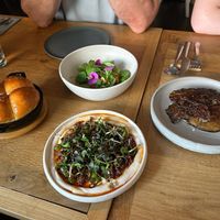 Starters of milk bread, fried apricot salad, white bean and harissa puree and aubergine crisps with minty tabbouleh at Bistro Lupa in Copenhagen