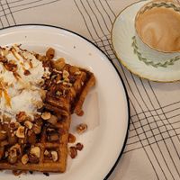 Belgian waffles topped with whipped cream, hazelnuts, and apple compote with a cafe breve. Delicious! at Acorn Community Cafe in Eugene