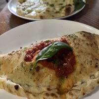 Vegan Calzone (four cheese pizza in the back)   at Intz48 Coffee Roasters Azores in Sao Miguel