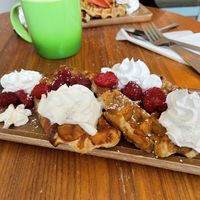 Waffles and raspberries with whipped cream   at Love Peace & Coffee in Edinburgh