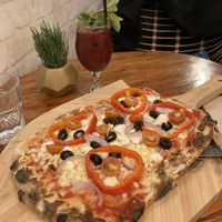 Very delicious and filling Greek pizza with Vegan Up juice  at Nomas in Macclesfield