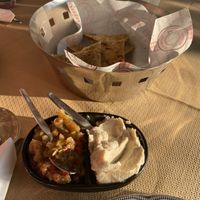 Complimentary lemon hummus and eggplant dip with pita  at Pheidias Grill House in Olympia