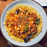 Moroccan Chickpea Stew with homemade harissa, preserved lemon, slivered toasted almonds, eggplant, date apricot chutney, saffron, and orange-sumac couscous  at Moosewood Restaurant in Ithaca
