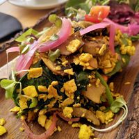 vegan Scrambled eggs with tofu and curry, spinach, mushrooms, pickled onion, homemade turmeric bread and "ramallet" tomato. at MaiMai Surf Bar in Mallorca