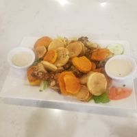 Fried potatoes, yams, and cauliflower sitting on top of salad with tahini sauce! at Allan's Mediterranean Bar and Grill in Middletown