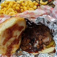BarBQ jackfruit sandwich with sides of grilled Mac & cheese, mixed greens at Planet Vegan in Houston