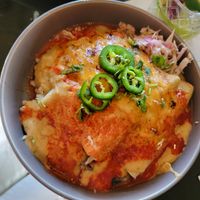 Birria enchiladas. This one was mine, it was excellent 💓 The bed of rice and beans is hidden beneath queso at Casa Del Vegano in Dallas