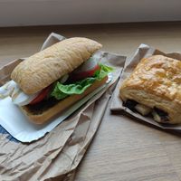 Ein Schokocrossaint und ein belegtes Brötchen mit veganem Mozzarella, Tomaten und Pesto. at denn's BioMarkt - Luegallee in Dusseldorf