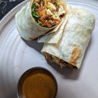 Vegan sausage burrito, comes with tofu and greens, and hot sauce on the side. at Copa Vida in San Diego