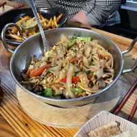 Vegan noodles with the chili crisp garlic French fries in the background   at M Pocha in Durham