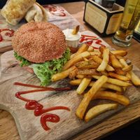Truffle burger on pink bun with fries and mayo at Vegan Temple Bar in Amsterdam
