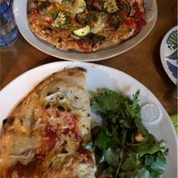 Vegan pizza and vegan calzone with side salad  at Sassy's in Oostende