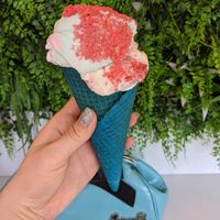 Raspberry ripple topped with candyfloss and sherbet in a colourful cone at Lick in Holmfirth