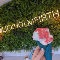 Raspberry ripple topped with candyfloss and sherbet in a colourful cone at Lick in Holmfirth