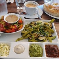Breakfast with warm eggplant, zucchini and green bell peppers, fresh salad, fresh focaccia, tasty dips at Pesto in Jerusalem