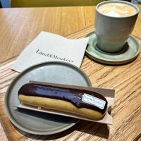 Eclair with chocolate and cafe latte, together 10,50€ (+0,50€ added to the eclair if eating on location). at Land & Monkeys - Amsterdam in Paris