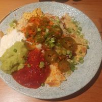 VEGAN NACHOS SHARER: TORTILLA CHIPS, VEGAN CHILLI,TOMATO SALSA, GUACAMOLE, VEGAN MAYO, VEGAN CHEESE & JALAPENDS at King Street Kitchen in Knutsford