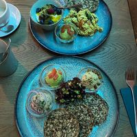 Two breakfast plates, one with scrambled tofu and one with three spreads at Emmi's Kitchen in Augsburg